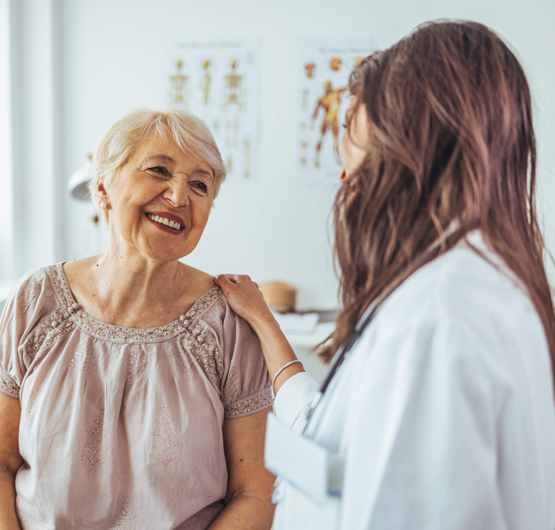 A smiling elderly woman in a consultation with a female doctor.