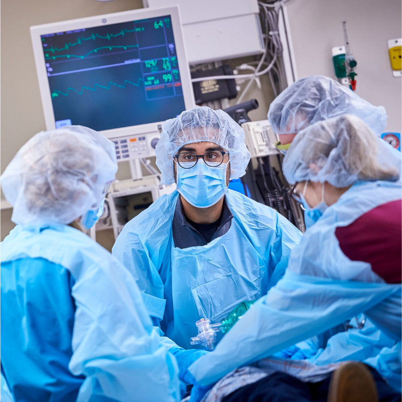 East Hampton surgical team in an operating room, with one surgeon looking up.