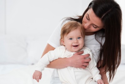 madre sosteniendo y besando a su bebé