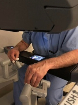 Photo of physician controlling robot in surgery