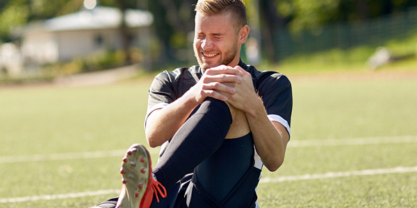 soccer player in pain holding knee