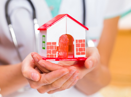 doctor holding a model of a home