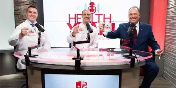 Physicans sitting at table discussingn health topics