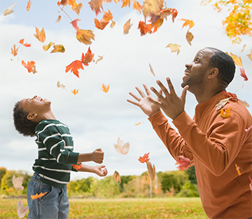 Dad and Son enjoying falling leaves