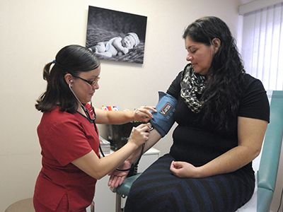 Personal médico que toma la presión arterial de un paciente.