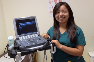 Staff member posing next to laptop