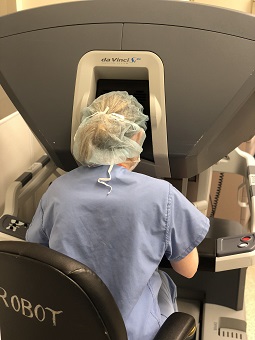 Photo of a physician controlling a robot in surgery