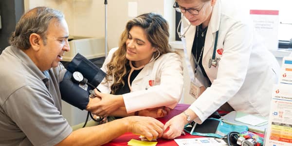 Nurse applying blood pressure cuff to arm