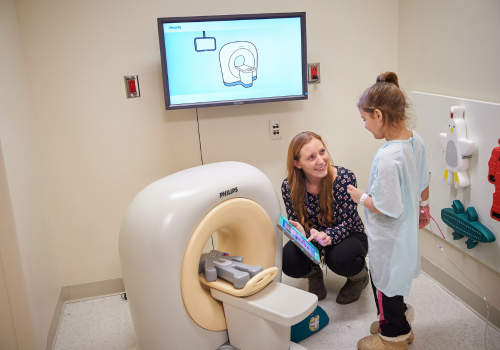 Especialista en vida infantil demuestra una máquina de tomografía computarizada